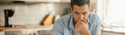 man thinking in kitchen