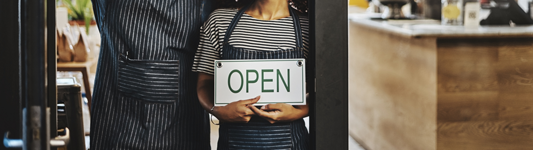 couple holding open sign