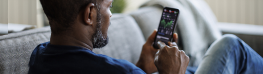 Man holding phone showing markets