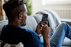 Man holding phone showing markets