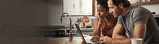 couple on laptop in kitchen