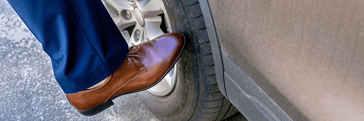 foot kicking a tire